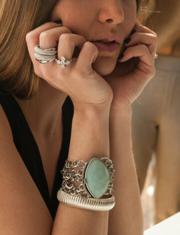 Frau mit Modeschmuck am Arm und Fingern