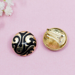 goldene Ohrclips von Pierre Lang mit schwarzen Ornamenten, Detail